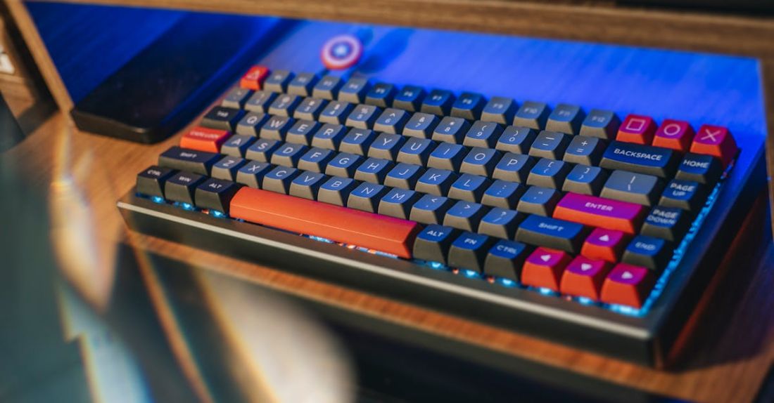 Smart Grids - From above contemporary mechanical keyboard of black and red colors with lightning placed on wooden computer desk