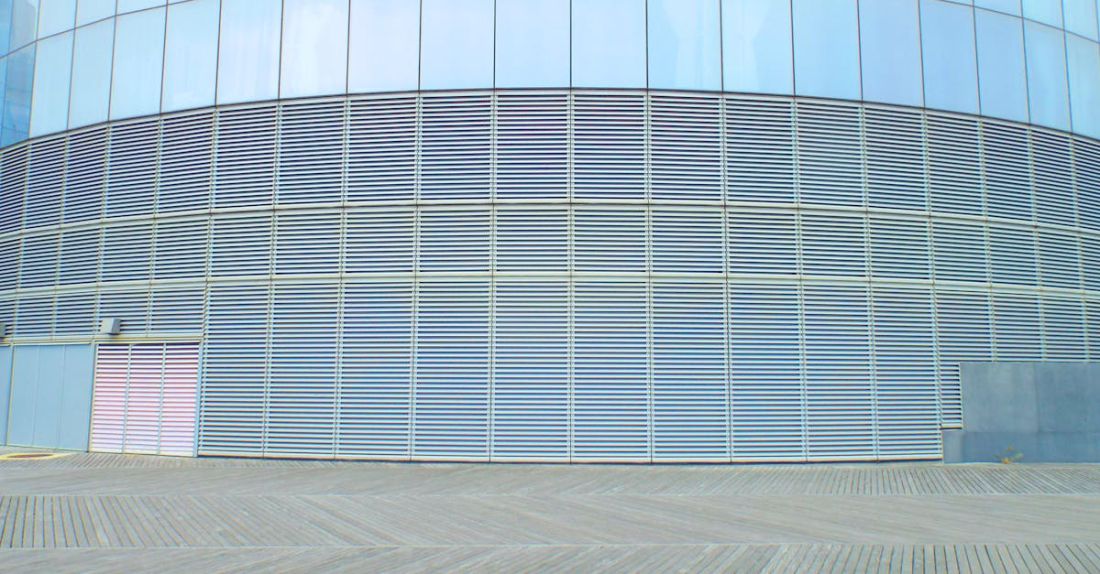 Solar Shading - Contemporary glass building wall with aluminum solar facade shading panels on clear sunny day