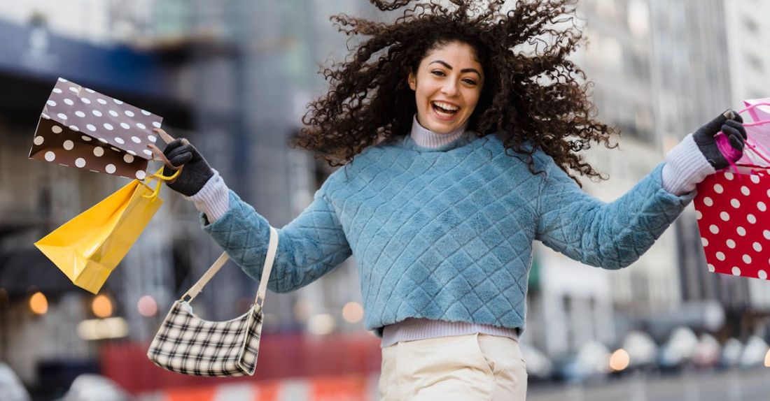 Waste Audits - Happy woman jumping with shopping bags