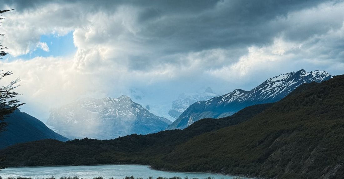 Natural Ventilation - A view of a river and mountains under a cloudy sky