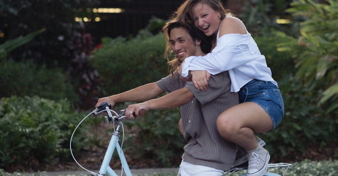 Bike-Sharing - A woman is riding a bike with a man on top