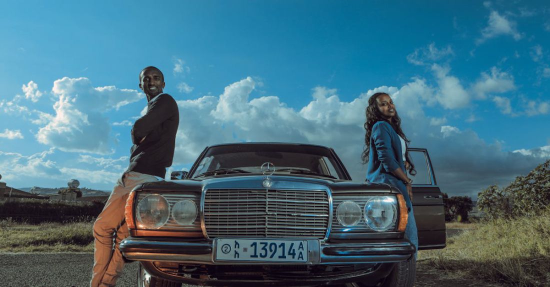 Car-Free Zones - Stylish black couple standing near retro car in countryside